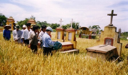 Tác giả và người trong dòng tộc cầu nguyện trước phần mộ cụ Trần Văn Bản (mộ lớn), mộ Bà Bản và một người con (2 mộ nhỏ)